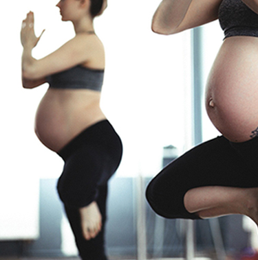 Femme enceinte effectuant une posture de yoga reflétée dans un miroir