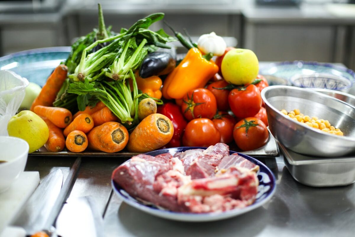 Vibrant assortment of fresh vegetables and meat on a kitchen counter for cooking inspiration.
