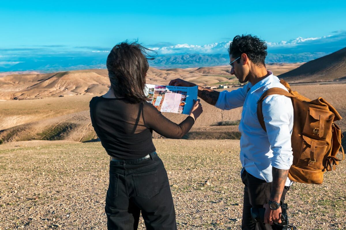 Two people examining a map in the stunning desert landscape of Marrakech-Safi, Morocco.