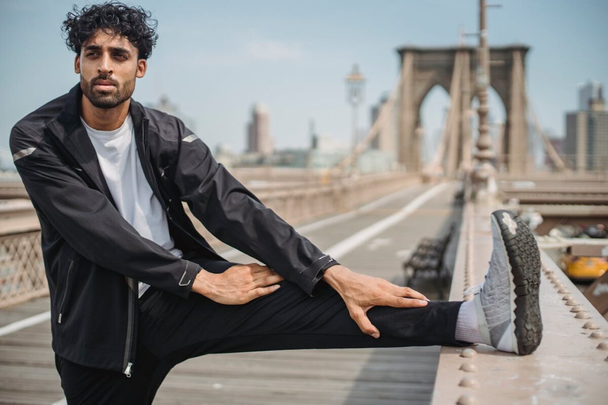 Man in sportswear stretching on the iconic Brooklyn Bridge, NYC.